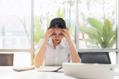 Ofiste baş ağrısı olan yorgun Asyalı İş Kadını, görsel migren, retinal migren, monoküler migren. İş yerinde hasta hissediyorum. İş kavramında aşırı çalışma düşünme