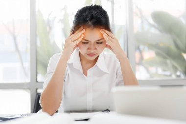 Ofiste baş ağrısı olan yorgun Asyalı İş Kadını, görsel migren, retinal migren, monoküler migren. İş yerinde hasta hissediyorum. İş kavramında aşırı çalışma düşünme