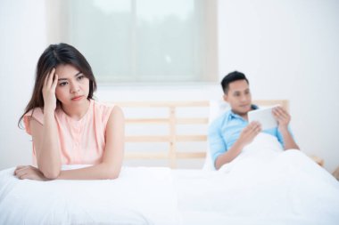 Sosyal Yoksay, Kocası bir tablet sosyal online izlerken yatakta karısının üzgün komik. Bu Smartphone yüz veya Nomophobia Sendromu, Ilişki kavramı sorunu