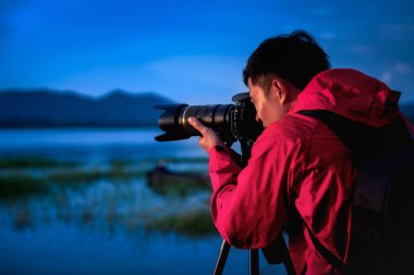 Seyahat fotoğrafçısı, gün batımında gölden gece hayatına, dikkat çekici doğa dağ manzarası ve göle odaklanma, Doğal fotoğrafçılık rahatlatıcı konsepti ile gün batımında gölile fotoğraf çektiriyor.