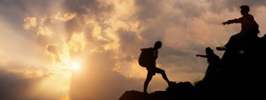 Doğal güzel bir zamanda güneş ışığı tanrısı ile gökyüzü işaret tırmanma ekibinin silueti. Başarılı bir kişinin ödül kavramı.