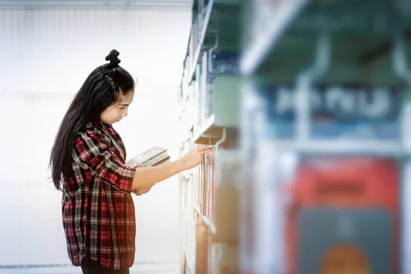 亚洲学生在国际学院 大学图书馆的书架上寻找课本 为大学考试的问题找到正确答案 — 图库照片