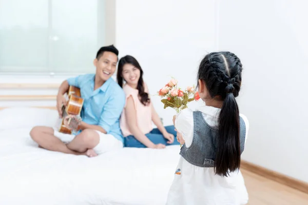 Asian people, Happy family in bedroom at home. Mother, Father and the children playing, Activities of family members are good family health of three people Education of kids, Health Insurance concept.