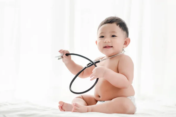 Asiatische Baby Junge Lächelt Und Spielt Stethoskop Auf Dem Bett — Stockfoto