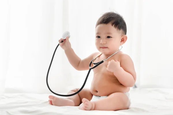 Asiático Bebé Niño Sonriendo Juega Estetoscopio Cama Fondo Blanco Salud — Foto de Stock