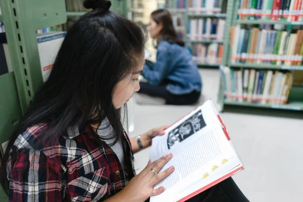 아시아 여학생 도서관 바닥에 도서관에서 책장에서 교과서 — 스톡 사진