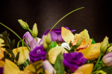 Bir ağaç kutusunda sarı orkide buketi