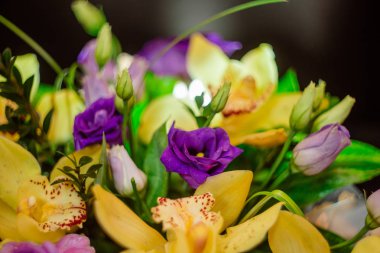 Bir ağaç kutusunda sarı orkide buketi