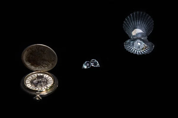 Deniz kabuğu, eski cep saati, Rhinestones ile kompozisyon. Siyah arka plan. Natürmort. Süsbitkileri.