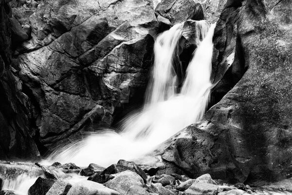 Beautiful small waterfall in mountains. Boulder, USA. Black and white.Long exposure.
