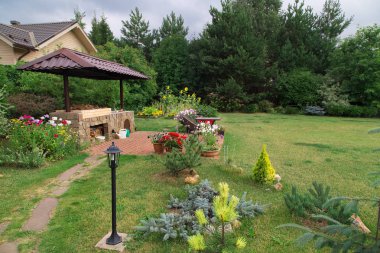 Arka bahçe veranda alan şömine ve mobilya ile. Yeşil parti alanı. Barbekü alanı. Taş.