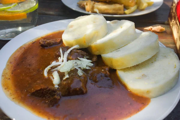 Czech Food: Traditional goulash with knedle on the table close-up.