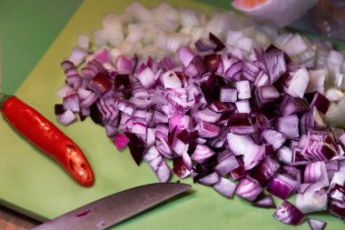 Chopped Purple and white onions on cutting board. Red pepper, knife. Food ingredients.