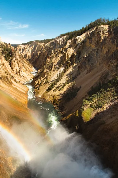 Yellowstone canyon, river, waterfall, water mist. Rainbow above the Lower Falls of the Yellowstone River. Wyoming, USA