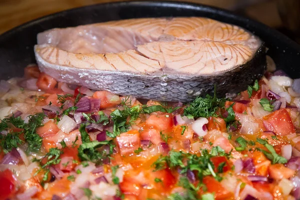 Salmon steak with vegetables on frying pan. Salmon steak with vegetables roasting on frying pan. Cooking.