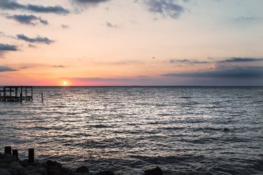 Gündoğumu veya günbatımı denize. Sunrise bulutlar. Güneş ufuk ortaya çıktı. Ahşap iskele.