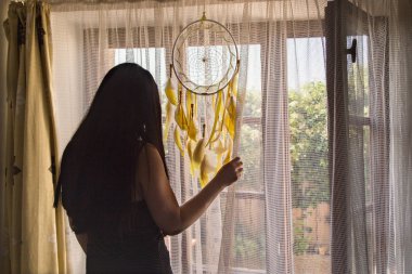 Esmer Kadın ayakta ve pencereden dışarı bakıyor - arka görünüm. 