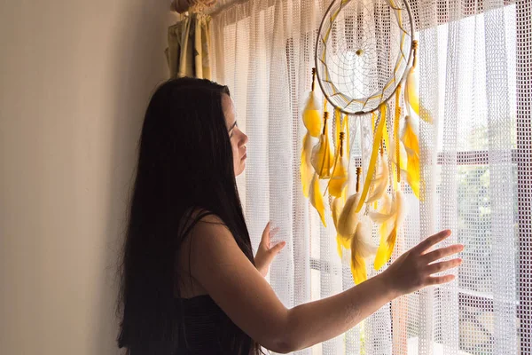 Esmer Kadın gün doğumu sırasında pencereden dışarı bakıyor - yan görünüm. Uyan.