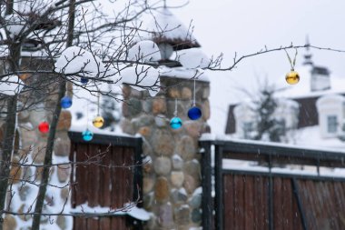 Noel dekorasyonu ile karda kış bahçesi. Asma olorful Xmas kabarcıklar ve ahşap çit.