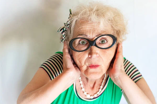 Пожилая красивая женщина с удивленным выражением лица — стоковое фото