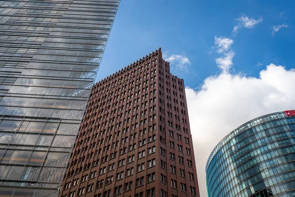 Bottom-up view of skyscrapers. Houses of glass, concrete and brick against the blue sky. Berlin, Germany, Europe.