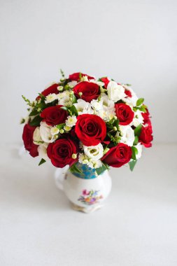 Masanın üzerinde bir vazoda düğün buketi