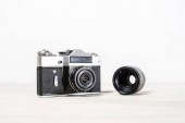 Stará retro kamera a čočka na bílém pozadí