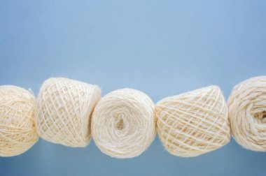 Mavi arka plan üzerinde üst üste çok renkli yün iplik topları üst görünümü