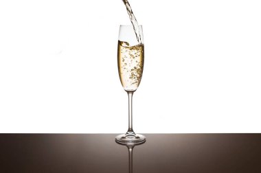 Şampanya beyaz bir arka plan üzerinde gözlük içine dökülür