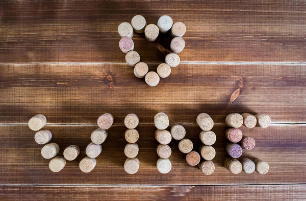 Heart and the word wine from wine corks on a wooden table. I love wine.