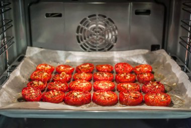 Fırında baharatlı, sarımsaklı ve zeytinyağlı kurutulmuş domates var.