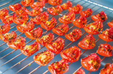 Fırındaki tel askıda güneşte kurutulmuş domates dilimleri. Yakın çekim, makro