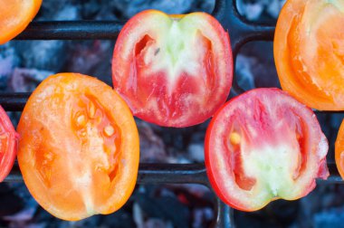 Küçük kırmızı ve sarı domates dilimleri ızgarada kızartılır. Yukarıdan görüntüle