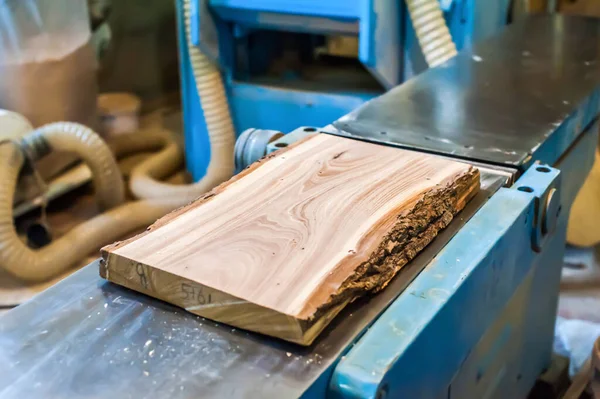 木工工房の大型木工機械の上に木製板が置かれています — ストック写真