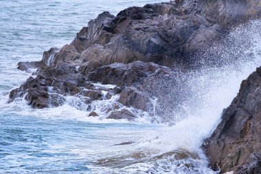 Kayaya çarpan bir dalga havaya püskürtür ve doğanın gücünü gösterir..