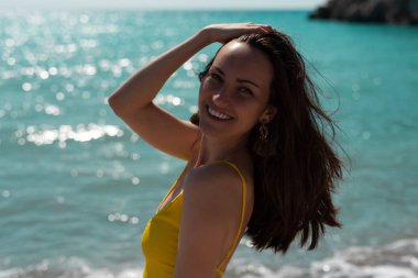 Sert ışık parlak güneşin sarı bir mayo, gerçek hayat denizde genç bir kadın büyük portre.