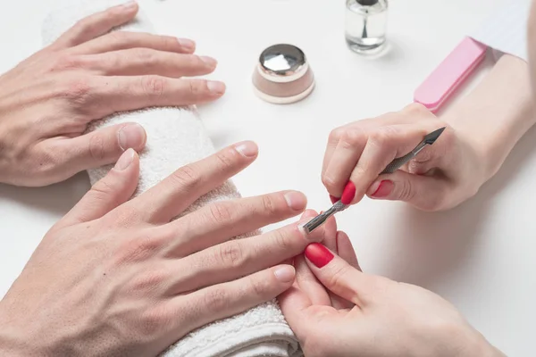 Mannen manicure. handen van de schoonheidsspecialiste behandeld cuticula van mannelijke handen met behulp van de Opdringer, schraper — Stockfoto