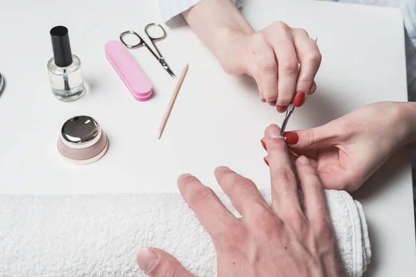 Mannen manicure. handen van de schoonheidsspecialiste behandeld cuticula van mannelijke handen met behulp van de Opdringer, schraper — Stockfoto