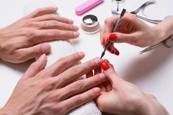 Mannen manicure. handen van de schoonheidsspecialiste behandeld cuticula van mannelijke handen met behulp van de Opdringer, schraper — Stockfoto