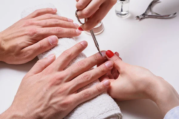 Mannen manicure. vrouw schoonheidsspecialiste behandelt nagelriemen van droge mannelijke handen — Stockfoto