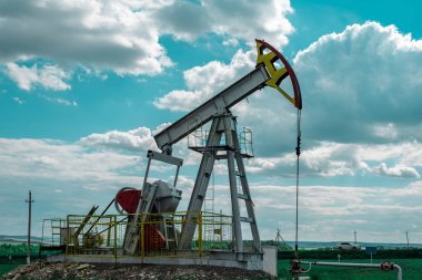 Petrol pompa kule mavi bulutlu gökyüzü ile yeşil çim alanı.