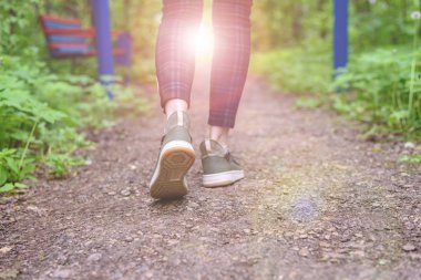 Ekose tozluk ve yeşil spor ayakkabı ince kadın bacakları orman yolu gidin. Temiz havada yürüyüşler.