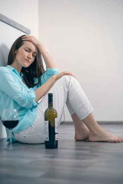 Junge Frau Die Auf Dem Boden Sitzt Und Wein Trinkt — Stockfoto