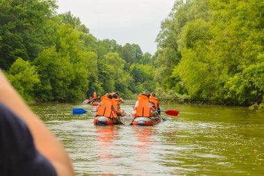 bir grup insan turuncu can yelekleri Nehri üzerinde bir şişme Katamaran üzerinde satışa çıkardı.