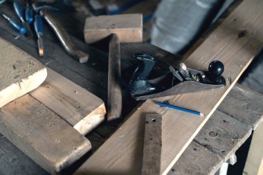 Planya, çekiç, kalem, köşe, keski, balta yalan komiteler, marangoz atölyesi ile ahşap bir masa üzerine