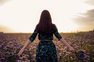 Bir buket çiçek alan Mor çiçek ile kadın esmer arkasından profil günbatımı, özgürlük, rüyalar