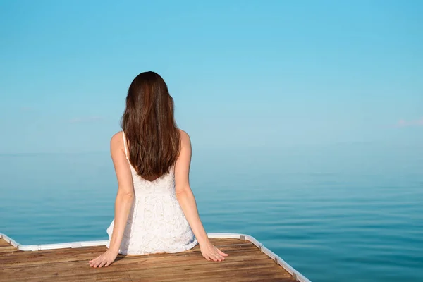 Mulher Solitária Vestido Branco Sentado Cais Olhando Para Mar — Fotografia de Stock