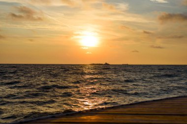 Okyanus dalgaları kıyıya yakın ile minimalist turuncu gündoğumu