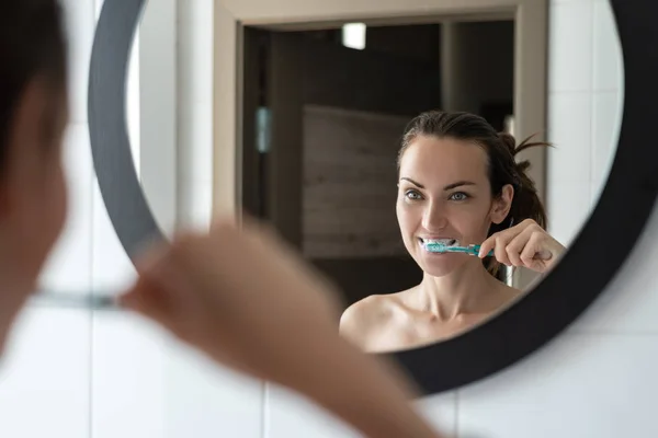 Jonge Brunette Vrouw Haar Tandenpoetsen Voor Badkamerspiegel — Stockfoto