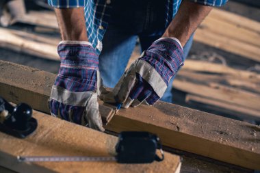 İnşaat, çatı kaplama, ahşap işleme. Yakın çekim bir marangoz El, bir işçi bir kalem ile ahşap bir gemide bir işareti yapar.